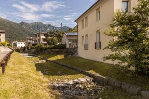 una casa con un patio de césped al lado de un edificio en Casa piccola, en Cison di Valmarino