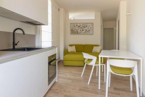 cocina y sala de estar con mesa y sillas en Casa piccola, en Cison di Valmarino