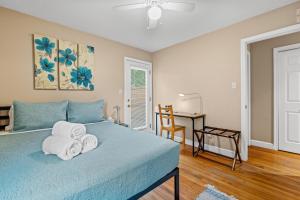 a bedroom with a blue bed with towels on it at 2 Bed Townhouse: Minutes from DCA-National Airport in Alexandria