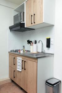 a kitchen with wooden cabinets and a sink at Apto nuevo a 5 min del Movistar Arena in Bogotá