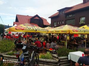 a group of people sitting at tables under umbrellas at WELLNESS Penzion Triola in Kořenov