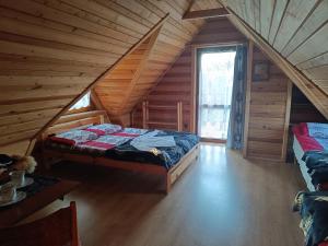 a attic room with a bed in a log cabin at Pokoje u Joanny in Ząb