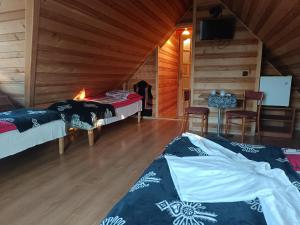 a room with two beds and a table in a cabin at Pokoje u Joanny in Ząb +2 photos