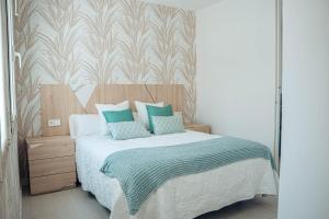 a bedroom with a bed with green and white pillows at Apartamentos La Moneda in Burgos