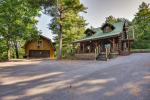 a large wooden house with a garage in the woods at Charming Wellesley Island Cabin Near State Parks 