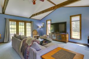 a living room with a couch and a tv at 1 Mi to River Cabin with Fire Pit in Milanville! in Milanville