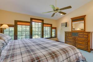 a bedroom with a bed and a ceiling fan at 1 Mi to River Cabin with Fire Pit in Milanville! in Milanville