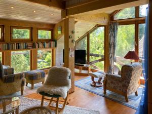 ein Wohnzimmer mit Holzwänden und einem großen Fenster in der Unterkunft Ammergauer Ferienidyll in Unterammergau