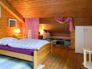 ein Schlafzimmer mit einem Bett in einer Holzhütte in der Unterkunft Ammergauer Ferienidyll in Unterammergau
