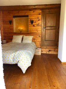 um quarto com uma cama e uma parede de madeira em Charmant 65m2 privé dans maison & terrasse vue Larzac em Saint-Jean-de-la-Blaquière