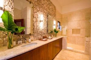 a bathroom with a sink and a stone wall at Sunny Vacation Villa No 35 in San Rafael del Yuma