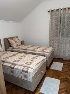 two twin beds in a room with a window at Guest Radic Apartments in Palić