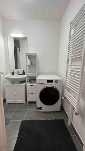 a white kitchen with a washer and a sink at Appartement Cozy - Quartier résidentiel in Melun