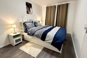 a bedroom with a blue and white bed and a window at Appartement Cozy - Quartier résidentiel in Melun