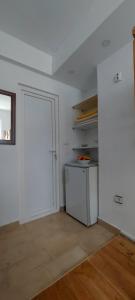 una habitación vacía con una puerta blanca y una cocina en KULIC, en Plužine