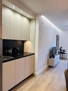 a kitchen with white cabinets and black counter tops at VuT - El Balcón de la Plaza - A in Ciudad-Rodrigo