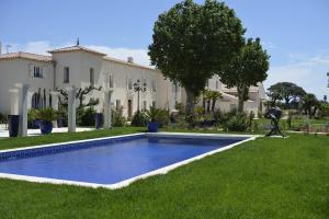 a swimming pool in the grass in front of a building at Chateau de la Clapiere in Hyères