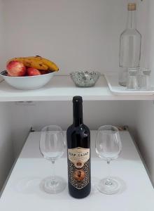 Una botella de vino y dos copas de vino en una nevera. en KULIC, en Plužine