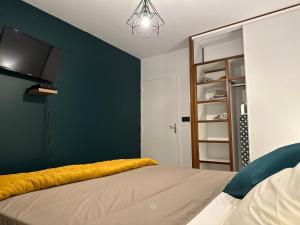 a bedroom with a bed and a tv on a wall at Le petit colibri in Rémire-Camp