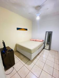 um quarto com uma cama e uma televisão em Linda Kitnet Mobiliada Mar Itapua em Vila Velha