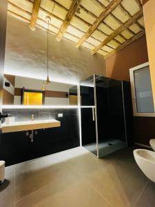 a bathroom with a sink and a glass shower at Rosy Room Design in Marsala