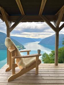 a bench on a deck with a view of a lake at Raaum Gard, hytte 2 in Hafslo
