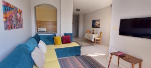 Villages road & promenade apartments في الغردقة: غرفة معيشة مع أريكة زرقاء وتلفزيون