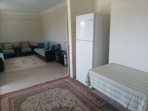 a living room with a white refrigerator and a couch at Denize 3km Daire - Piraziz Giresun in Giresun