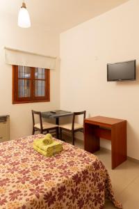 een slaapkamer met een bed met een tafel en een tafel bij El Amparo Hotel in San Luis