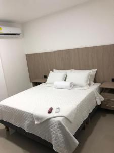 - une chambre avec un grand lit blanc et des draps blancs dans l'établissement Hotel Ocean Boutique Maicao, à Maicao