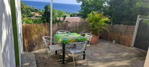 una mesa y sillas en un patio en Evasion Nord Caraïbe vue mer -plage 5 mn à pieds en Le Carbet
