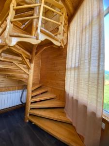 Cama de madera en habitación con escalera en Карпатський затишок en Verkhovyna