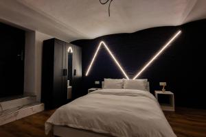 - une chambre dotée d'un lit avec des lumières sur le mur dans l'établissement Juno, à Sibiu