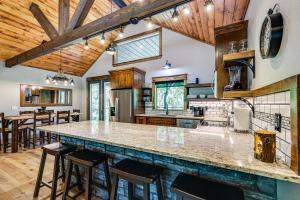 a kitchen with a large island in a kitchen with wooden ceilings at Big Cedar Vacation Rental with Deck and Hot Tub! in Hodgen
