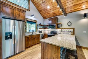 a kitchen with wooden cabinets and a stainless steel refrigerator at Big Cedar Vacation Rental with Deck and Hot Tub! in Hodgen +18 photos