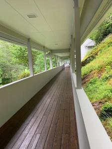 une terrasse couverte vide d'une maison revêtue de parquet dans l'établissement Majestic 5 BR House on Mt. Mitchell Golf Course, à Busick