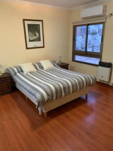 uma cama num quarto com piso em madeira em Departamento céntrico amueblado - 4 personas em Concordia