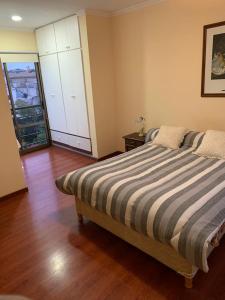 um quarto com uma cama e piso em madeira em Departamento céntrico amueblado - 4 personas em Concordia