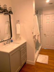 La salle de bains est pourvue d'un lavabo et d'une douche avec un miroir. dans l'établissement Majestic 5 BR House on Mt. Mitchell Golf Course, à Busick