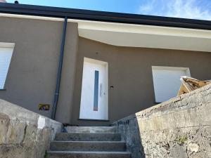 uma escada que leva a uma casa com uma porta branca em 154 - casa vacanze em Villaurbana