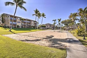 a walkway in front of a building with palm trees at Kona Coast Resort Condo Oceanfront Property! in Kailua-Kona