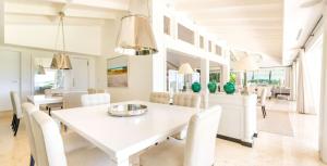 a dining room with a white table and white chairs at Sunny Vacation Villa No 37 in San Rafael del Yuma