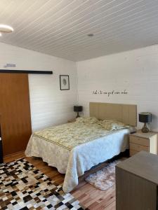 a bedroom with a bed and a sign on the wall at Pousada Recanto entre Rios CHALE SOL NASCENTE in Urubici