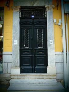 una grande porta nera su un edificio di Αρχοντικό Κάββουρα 1890 a Nafpaktos