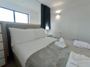 a bedroom with a large white bed and a window at 1 Bedroom Duplex Apartment in Manchester in Manchester