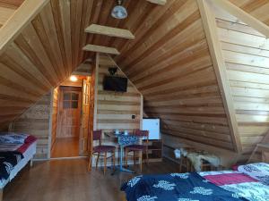 a room with a wooden ceiling with a table and chairs at Pokoje u Joanny in Ząb