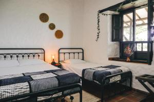 a bedroom with two beds and a window at Casa Luna Hotel Campestre & Spa in San Gil