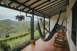 a porch with a hammock and a view of the mountains at Casa Luna Hotel Campestre & Spa in San Gil