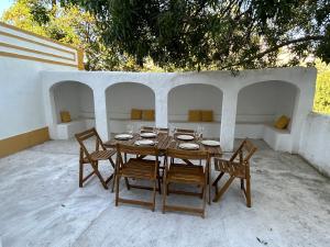 una mesa de madera y sillas con platos y copas de vino en Casa do Martinho, en Castelo de Vide
