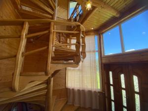 a spiral staircase in a cabin with windows at Карпатський затишок in Verkhovyna